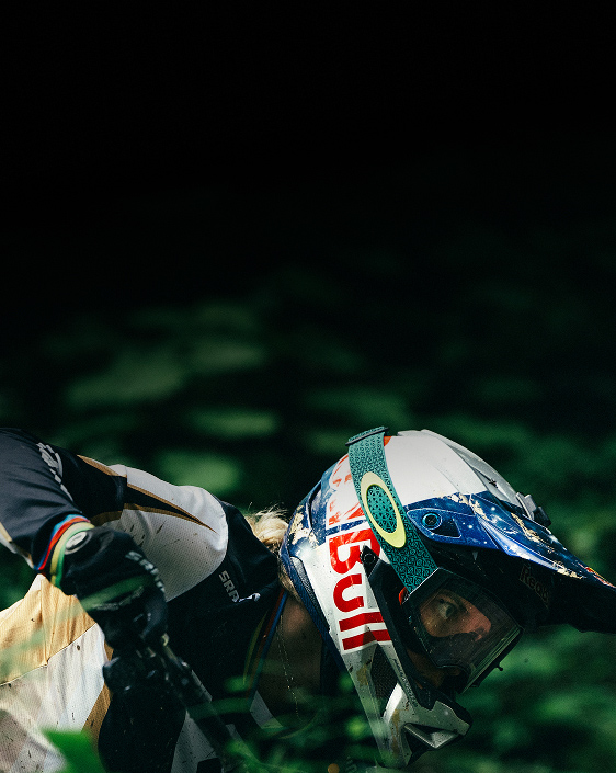 Vali Höll biking through a lush green forest.